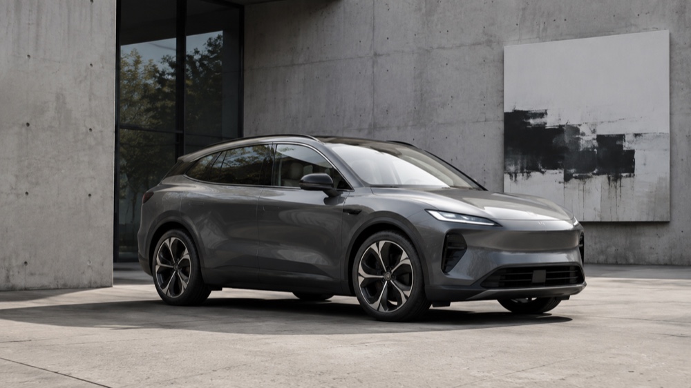 Moderne Audi på en lys vej foran nutidig arkitektur